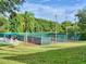 Outdoor tennis courts surrounded by lush landscaping providing a vibrant playing environment for tennis enthusiasts at 25524 Maurepas Ln, Leesburg, FL 34748