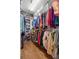 Organized walk-in closet with shelving, hanging rods, and games stored within, and hardwood floors at 25524 Maurepas Ln, Leesburg, FL 34748