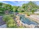 Serene water feature with a stone bridge and lush landscaping offers a peaceful community space at 25524 Maurepas Ln, Leesburg, FL 34748