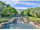 Scenic waterfall and stone bridge create a tranquil focal point within lush landscaping near the clubhouse at 25524 Maurepas Ln, Leesburg, FL 34748