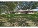 Spacious backyard featuring mature trees and a well-manicured lawn, providing a serene outdoor setting at 27022 Racquet Cir, Leesburg, FL 34748