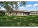 Large backyard featuring a well-maintained lawn and a screened-in porch at 27022 Racquet Cir, Leesburg, FL 34748