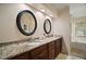 Elegant bathroom with double sinks, granite countertops, and a separate bathtub and shower at 27022 Racquet Cir, Leesburg, FL 34748