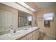 Bright bathroom featuring double sinks, a large mirror, and a shower/tub combo at 27022 Racquet Cir, Leesburg, FL 34748
