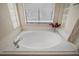Relaxing soaking tub with tile surround and decorative accents at 27022 Racquet Cir, Leesburg, FL 34748