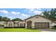 Charming single-story home with a manicured lawn and attached two-car garage, showcasing classic curb appeal at 27022 Racquet Cir, Leesburg, FL 34748