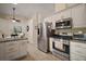 Functional kitchen with stainless steel appliances, white cabinets, and an adjacent dining area at 27022 Racquet Cir, Leesburg, FL 34748