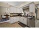 Well-lit kitchen featuring white cabinets, granite countertops, and stainless steel appliances at 27022 Racquet Cir, Leesburg, FL 34748