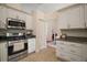 Efficient kitchen with stainless appliances, and white cabinets at 27022 Racquet Cir, Leesburg, FL 34748