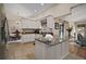 Bright kitchen with granite countertops, white cabinets, stainless appliances, and access to living room at 27022 Racquet Cir, Leesburg, FL 34748