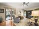 Bright living room leading to screened patio, featuring hardwood floors and neutral tones at 27022 Racquet Cir, Leesburg, FL 34748