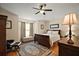 Inviting main bedroom with a dark wood bed frame, soft lighting, and a comfortable seating area at 27022 Racquet Cir, Leesburg, FL 34748