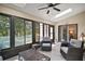 Bright sun room with tile flooring, ceiling fan, and sliding glass doors leading to the outdoor patio at 27022 Racquet Cir, Leesburg, FL 34748