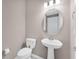 Half bath featuring a toilet and a pedestal sink with a decorative mirror at 2786 Top Hill Ct, Minneola, FL 34715