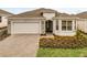Charming single-story home featuring a neatly landscaped front yard and a two-car garage at 2786 Top Hill Ct, Minneola, FL 34715