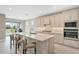Modern kitchen boasts a large island with seating, stainless appliances, and stylish backsplash at 2786 Top Hill Ct, Minneola, FL 34715