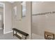 Modern shower area featuring a bench, tiled walls, and a glass shower door at 2786 Top Hill Ct, Minneola, FL 34715
