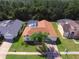 Aerial view of a charming home with a screened-in pool, lush landscaping and mature trees at 2855 Picadilly Cir, Kissimmee, FL 34747
