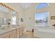 Bright bathroom featuring double sinks, soaking tub and ample natural light, perfect for relaxation at 2855 Picadilly Cir, Kissimmee, FL 34747