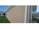 Beige exterior siding with white trim and a glimpse of the sunroom windows at 3096 Maywood Ct, The Villages, FL 32162