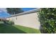 Beige exterior siding with green grass, and leafy green bushes along the side at 3096 Maywood Ct, The Villages, FL 32162