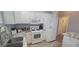 Bright kitchen with white cabinetry, stone countertops, and modern appliances, with a view into the hallway at 3096 Maywood Ct, The Villages, FL 32162