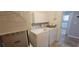 Bright laundry room features washer, dryer, storage cabinets, and a peek into a well-lit kitchen at 3096 Maywood Ct, The Villages, FL 32162