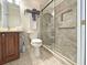 Tiled bathroom with wood vanity, updated sink, frameless glass shower with granite backsplash and shower niche at 3325 Archer Ave, The Villages, FL 32162