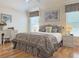 Bright bedroom with hardwood floors, decorative window valances, and a comfortable bed with matching nightstands at 3325 Archer Ave, The Villages, FL 32162