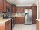 Updated kitchen features stainless steel appliances, wooden cabinets, and a refrigerator with a water dispenser at 3325 Archer Ave, The Villages, FL 32162
