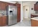 Modern kitchen showcasing stainless steel refrigerator and wood cabinets, accented by tile flooring and backsplash at 3325 Archer Ave, The Villages, FL 32162