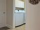 The laundry room includes a modern washer and dryer set, complemented by ample cabinet space above at 3325 Archer Ave, The Villages, FL 32162