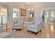 Cozy living room showcases hardwood floors, two armchairs, and seamless access to the adjacent dining area at 3325 Archer Ave, The Villages, FL 32162