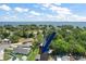Aerial view of neighborhood with canal leading to a large lake, lush greenery and the blue arrow points to a boathouse at 33635 Jeffery Ct, Leesburg, FL 34788