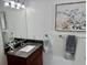 A stylish bathroom featuring a decorative mirror, granite countertops and elegant lighting at 33635 Jeffery Ct, Leesburg, FL 34788