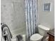 This bathroom showcases a tiled shower and tub combination with a marble-patterned shower curtain at 33635 Jeffery Ct, Leesburg, FL 34788