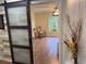 A bedroom can be seen beyond a sliding barn door and features a ceiling fan and beautiful floors at 33635 Jeffery Ct, Leesburg, FL 34788