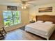 Bedroom features a tropical view outside the window, along with beach themed art and comfortable rocker at 33635 Jeffery Ct, Leesburg, FL 34788
