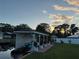 Scenic view of a private boat dock with a boat and lush landscaping at sunset at 33635 Jeffery Ct, Leesburg, FL 34788