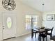 Bright dining area with elegant lighting, tiled floor, adjacent to a window view and front door at 33635 Jeffery Ct, Leesburg, FL 34788