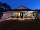 Exterior of home, with a well-lit porch, landscaped yard, and a driveway leading to the garage at 33635 Jeffery Ct, Leesburg, FL 34788