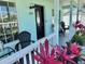 Inviting covered front porch featuring patio furniture, red ti plants, and an inviting front door at 33635 Jeffery Ct, Leesburg, FL 34788