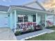Inviting covered front porch featuring patio furniture, red ti plants, and an inviting front door at 33635 Jeffery Ct, Leesburg, FL 34788