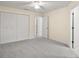 Spacious main bedroom with a ceiling fan, closet space, and an open doorway at 33635 Jeffery Ct, Leesburg, FL 34788