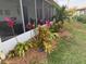 Landscaping features bright pink plants and lush greenery against a white patio, enhancing the outdoor space at 33635 Jeffery Ct, Leesburg, FL 34788