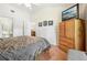 Bedroom with neutral walls, wood floors, TV, and doorway to bathroom at 340 Juniper Way, Tavares, FL 32778