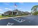 Community clubhouse featuring manicured landscaping, ample parking, and American flag at 340 Juniper Way, Tavares, FL 32778
