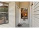 Covered front porch with light gray front door, window, outdoor decor, and light gray vinyl siding at 340 Juniper Way, Tavares, FL 32778