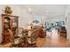 Cozy living room with wood floors, dining table, modern light fixture, and view to the lanai at 340 Juniper Way, Tavares, FL 32778
