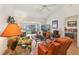 Comfortable living room featuring wood floors, neutral walls, a screened-in lanai and bedroom doorway at 340 Juniper Way, Tavares, FL 32778